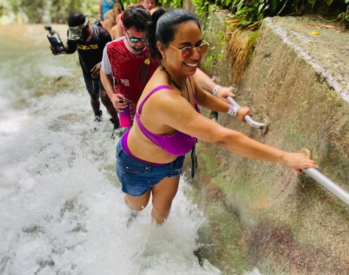 A climber holding the handrail beside the cascade at Dunn's River Falls