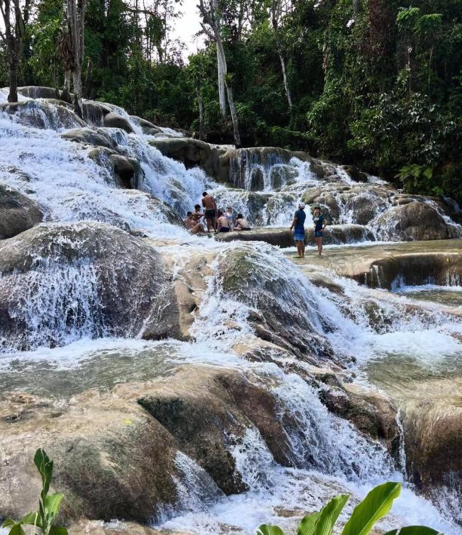 A guided group spread across the terraces at Dunn's River Falls